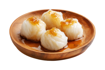 Coconut rice balls or dumplings topped with syrup and shredded coconut on wooden plate, isolated on white transparent background, concept of Polynesian Snacks Faikakai dessert cuisine
