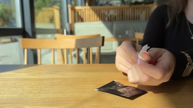 Young woman wipes hands meticulously with wet wipe. Female in brown shirt uses damp cloth to wipe fingers and remove dirt slow motion. High quality 4k footage