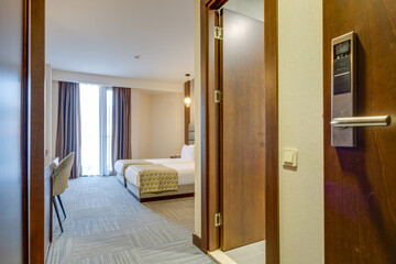 Comfortable and stylish hotel room featuring modern furnishings, a neatly made bed, and soft lighting, offering both relaxation and aesthetics for a pleasurable stay.