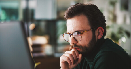 Obraz premium Businessman, computer or reading in office with thinking, planning or corporate review with glasses. Male person, problem solving or research analysis by tech, email or feedback insight at workplace