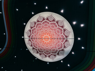 Illuminated Red and Orange Mandala Design on a Ceiling with Starry Lights