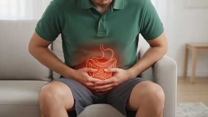 A man clutching stomach in pain with digestive system glowing over abdomen, showing discomfort from acidity, heartburn