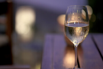 a glass of cold white wine and serving in the restaurant