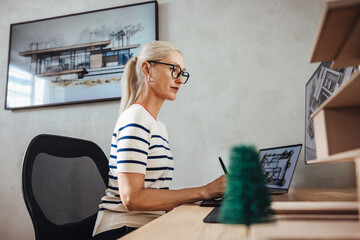 Mature female architect working on a project in a modern office