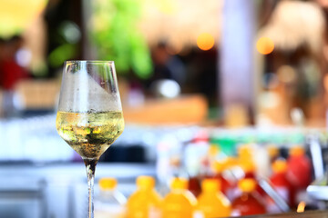 a glass of white wine served in a restaurant, abstract background of a summer restaurant