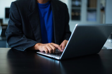 Professional man uses a phone and laptop to manage his business, highlighting modern work, digital communication, and career success.