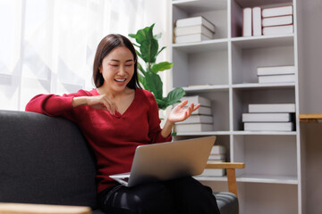 Young woman video conferencing on laptop at home