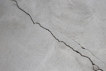 Close up of Diagonal Cracks in Cement Floor. Detail of cracked concrete surface.