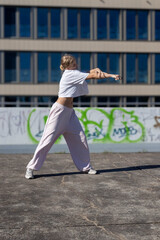 Fototapeta premium A young woman does dance exercises outdoors