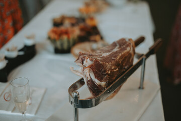 Un gros morceau de jambon cru servit pendant un apéro sur une table