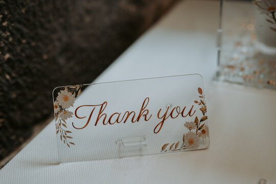 Un mot de décoration qui dit "Thank you" sur une table dans un mariage