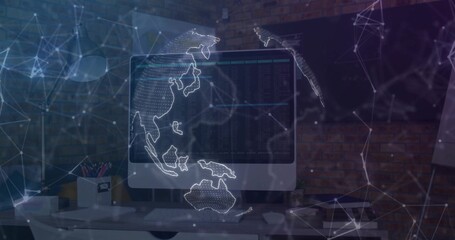 Displaying large monitor projecting network globe in tech workspace, with keyboard and lamp