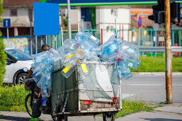 Man riding a bicycle with trailer with plastic bottles, waste exporting for recycle