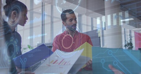 Analyzing man in red shirt interpreting printed charts at office desk, with data overlays