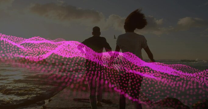 Running couple wearing t-shirts and shorts approaching shoreline at sunset, with pink wave overlay