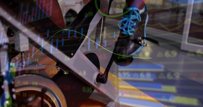 Fototapeta Pedaling exerciser's black shoe pressing on exercise bike pedal in gym, with trading chart overlay