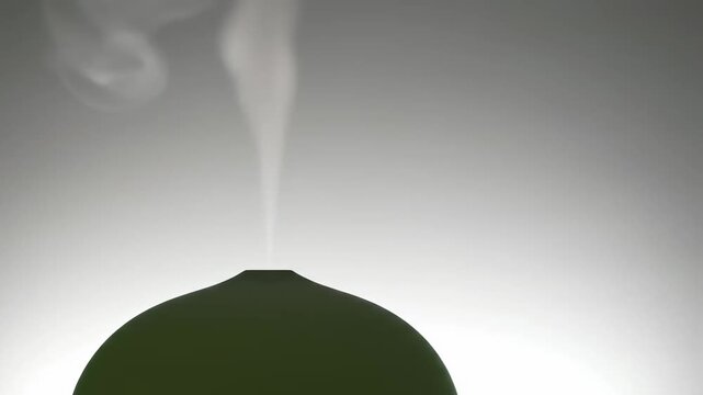 A modern green aroma diffuser releasing a gentle plume of steam for home aromatherapy and tranquil relaxation