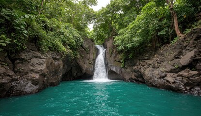 Fototapeta premium Lush waterfall cascading into a turquoise pool surrounded by dense jungle