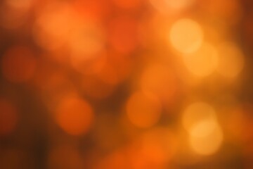 Fototapeta premium warm orange bokeh blur background with soft glowing circles and abstract light effect.