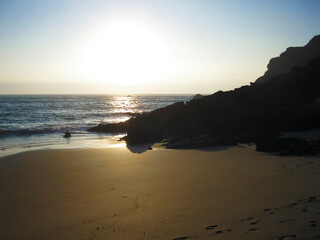A beautiful beach scene with the sun shining brightly on the water