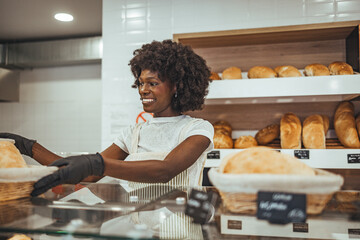 Smiling Employee Serving Freshly Baked Bread at a Local Bakery Shop