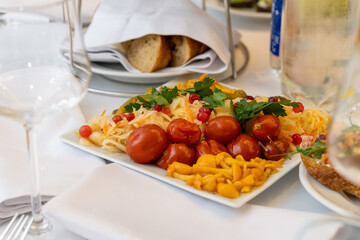 Marinated appetizers on a square white plate served on a festive holiday table