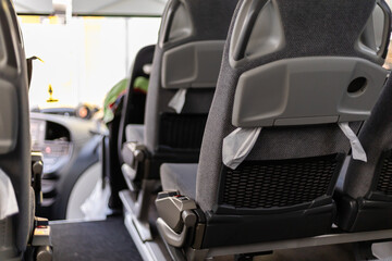 Inside a city bus during the daytime, the scene shows empty seats arranged neatly. The atmosphere is calm with sunlight filtering through the windows, highlighting the interior details