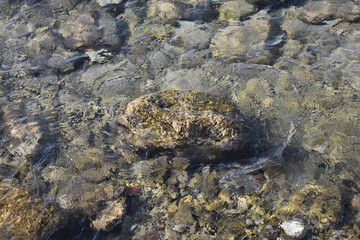 Historic port of Mandraki on the island of Rhodes, Greece. Stones under water. Natural background. Stone texture. Abstract background. Mediterranean Sea, Rhodes Island, Greece. Summer and holidays. 