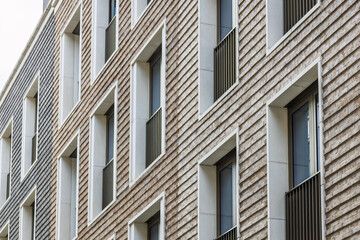 Contemporary masonry architecture with rhythmic geometric brick relief and framed windows