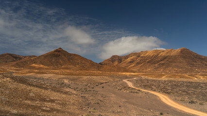 Dirt road through volcanic desert mountains, Fuerteventura, Canary Islands