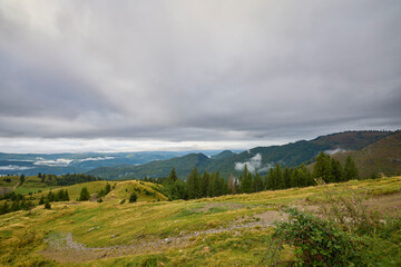 a beautiful mountain landscape in the Bucegi Mountains of Romania on a September day with clouds and fog.
