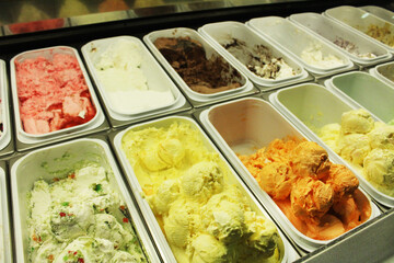 A large selection of ice cream in trays in the ice cream shop