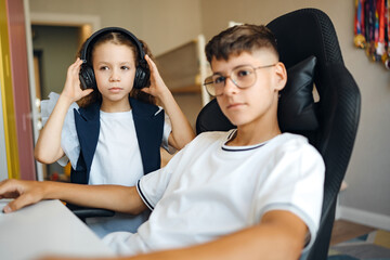 Two children engaged in gaming with headphones in a modern room