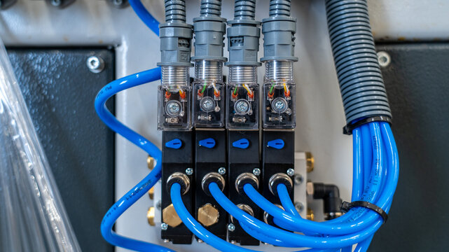 Macro Shot of Industrial Pneumatic Solenoid Valves with Blue Tubing
