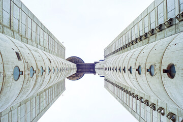 The Genex Tower in Belgrade: a bottom-up view. Tall concrete towers joined by a bridge on the upper floors. Symbol of urban identity, modernist heritage and post-war architectural expression in Serbia