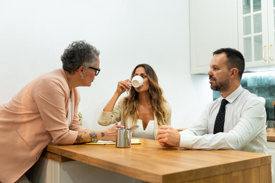 Business people discussing during coffee break in modern office kitchen - Powered by Adobe