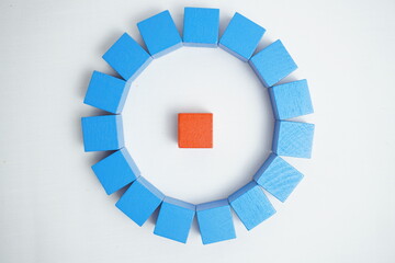 An orange cube positioned in the center, surrounded by evenly spaced blue cubes arranged in a...