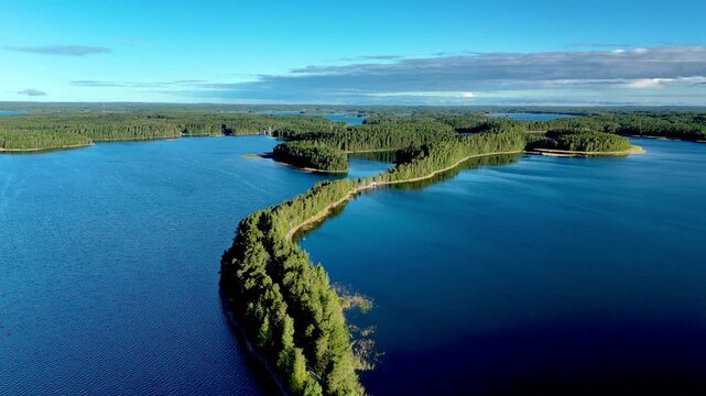 Experience the tranquil allure of Punkaharju, Finland, showcasing a winding nature bridge esker surrounded by shimmering lakes. This natural wonder captivates with its lush greenery and serene waters.