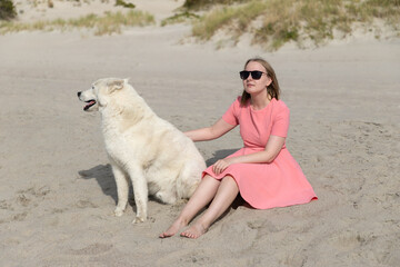 Young woman with her husky dog relaxing on the beach