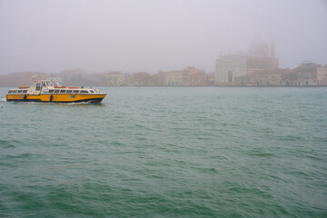 Venice's Alilaguna boat glides through fog on the Giudecca Canal