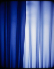 Obraz premium Indigo curtains hang gracefully, catching the sunlight that filters through, casting soft shadows and enhancing the tranquil vibe of the room. This scene invites relaxation and peace Generative AI