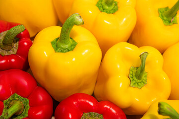 A close-up of several bell peppers. Red and yellow peppers close-up on a store shelf.