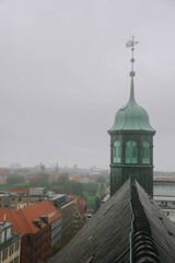 View of Trinitatis Kirke from the Round Tower in Copenhagen city, Denmark on rainy day.