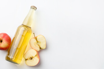 Fototapeta premium Delicious cider in glass bottle and apples on white background, flat lay. Space for text