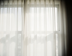 Bright light streaming through sheer grey curtains creates a serene atmosphere in an indoor space. The window frame is clean and modern, enhancing the tranquil setting Generative AI