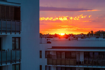 Morning sun rising over residential buildings, real estate market, new development, city, morning.