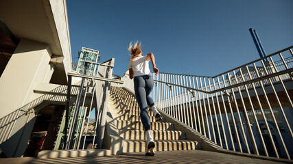Female Athlete Running Upstairs in Urban Scenery During Morning Workout