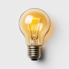 Close-up of a vintage-style incandescent lightbulb, glowing warmly against a plain white background