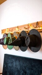 Witch hats on a wooden wall rack, lit by fairy lights