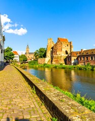 Cobblestone walkway alongside canal, historic European city buildings